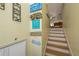 Staircase with light wood steps and beach-themed decorations, offering a warm, coastal feel at 2202 Donato Dr, Belleair Beach, FL 33786