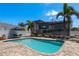 Stunning pool area with an outdoor kitchen, patio seating, and picturesque views of the surrounding landscape at 2202 Donato Dr, Belleair Beach, FL 33786