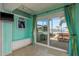 Relaxing sun room with sliding glass doors to a patio and canal views with built-in bench seating at 2202 Donato Dr, Belleair Beach, FL 33786