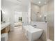 Bright bathroom showcasing a modern soaking tub, shower, and vanity with light wood cabinets at 2218 S Occident St, Tampa, FL 33629