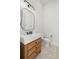 Modern bathroom featuring a wooden vanity, a rectangle mirror, and herringbone-patterned floors at 2218 S Occident St, Tampa, FL 33629
