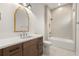 Bright bathroom featuring white tiled walls, a wooden vanity, and a soaking tub at 2218 S Occident St, Tampa, FL 33629