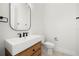 Modern bathroom featuring a wooden vanity, a rectangle mirror, and herringbone-patterned floors at 2218 S Occident St, Tampa, FL 33629
