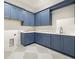 Well-equipped laundry room with ample cabinetry, counter space, and checkered tile flooring at 2218 S Occident St, Tampa, FL 33629