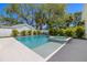 Backyard in-ground pool features an attached spa, surrounded by manicured landscaping and white fencing at 2218 S Occident St, Tampa, FL 33629