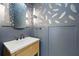 Stylish powder room with wood vanity, vessel sink, round mirror and unique wall paper at 2218 S Occident St, Tampa, FL 33629