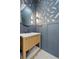 Stylish powder room with wood vanity, vessel sink, round mirror and unique wall paper at 2218 S Occident St, Tampa, FL 33629