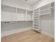 Spacious walk-in closet with custom shelving, hanging rods, and hardwood flooring at 2218 S Occident St, Tampa, FL 33629