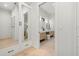 Bright walk-in closet showcasing mirrored cabinets and drawers, leading to a modern bathroom at 2218 S Occident St, Tampa, FL 33629