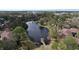 Aerial view showcasing a serene community lake with mature trees and well-maintained condo buildings around the perimeter at 2679 Sabal Springs Cir # 102, Clearwater, FL 33761