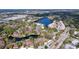This aerial view of the community shows the pond, complex, surrounding foliage, and ample parking areas at 2679 Sabal Springs Cir # 102, Clearwater, FL 33761