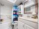 Clean bathroom with white vanity, bathtub with shower, and nautical-themed shower curtain at 2679 Sabal Springs Cir # 102, Clearwater, FL 33761