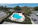 Aerial shot of a sparkling community pool with ample lounge seating, palm trees and adjacent covered area at 2679 Sabal Springs Cir # 102, Clearwater, FL 33761