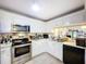 A fully-equipped kitchen boasts stainless appliances, white cabinets, and ample counter space at 2679 Sabal Springs Cir # 102, Clearwater, FL 33761