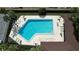 Overhead view captures the sparkling blue community pool, surrounded by lounge chairs and tables for relaxing at 2679 Sabal Springs Cir # 102, Clearwater, FL 33761