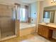 Well-lit primary bathroom with a glass shower, soaking tub, and vanity at 2820 Pankaw Ln, Valrico, FL 33596