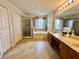 Primary bathroom featuring a dual sink vanity, garden tub, and walk-in shower at 2820 Pankaw Ln, Valrico, FL 33596