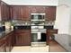 Kitchen boasting stainless steel appliances, granite countertops, and dark wood cabinetry at 2820 Pankaw Ln, Valrico, FL 33596