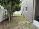 Side yard featuring a grassy area alongside the house, with a white fence enhancing privacy at 2820 Pankaw Ln, Valrico, FL 33596