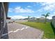 Spacious backyard featuring a gravel patio, lush lawn, and mature palm trees, perfect for outdoor enjoyment at 3078 Marine Grass Dr, Wimauma, FL 33598
