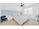 Airy bedroom with a large window, modern furnishings, and blue accent wall at 3078 Marine Grass Dr, Wimauma, FL 33598