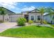 Charming single-story home with a well-manicured lawn and tropical landscaping at 3078 Marine Grass Dr, Wimauma, FL 33598