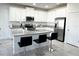 Spacious kitchen boasts an island with bar seating, white cabinets, and granite countertops at 3078 Marine Grass Dr, Wimauma, FL 33598
