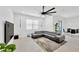 Modern living room with a grey sectional couch and view of the dining area and sliding glass door at 3078 Marine Grass Dr, Wimauma, FL 33598