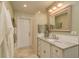 Bright bathroom featuring white vanity, decorative mirror, soft lighting, and a stylish white door at 3138 Edgemoor Dr, Palm Harbor, FL 34685