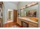 Bright bathroom featuring a vanity with stone counters, wood floors, and a walk-in shower at 3138 Edgemoor Dr, Palm Harbor, FL 34685