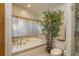 Relaxing bathroom with a soaking tub, soft lighting, and a separate shower at 3138 Edgemoor Dr, Palm Harbor, FL 34685