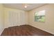 Bright bedroom with wood floors, large closet, window view, and neutral colored walls at 3138 Edgemoor Dr, Palm Harbor, FL 34685