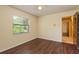 Cozy bedroom with hardwood floors, a bright window view, and a door leading to another area at 3138 Edgemoor Dr, Palm Harbor, FL 34685