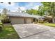 Charming single-story home features a gray stone front, beautiful landscaping, and an attached two car garage at 3138 Edgemoor Dr, Palm Harbor, FL 34685