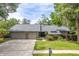 Charming single-story home features a gray stone front, beautiful landscaping, and an attached two car garage at 3138 Edgemoor Dr, Palm Harbor, FL 34685
