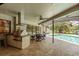 This outdoor kitchen area features a built-in grill, bar seating, ceiling fan and access to the pool and lanai area at 3138 Edgemoor Dr, Palm Harbor, FL 34685