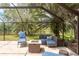 Relax in the screened-in patio with comfortable seating and a fire pit while enjoying the tranquil view of the lake at 3138 Edgemoor Dr, Palm Harbor, FL 34685