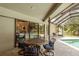 The screened patio offers ample seating with a table and chairs, perfect for dining al fresco overlooking the pool and lake at 3138 Edgemoor Dr, Palm Harbor, FL 34685