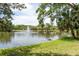 The serene pond with fountain creates a picturesque backdrop for the lush greenery surrounding this stunning property at 3138 Edgemoor Dr, Palm Harbor, FL 34685