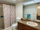 Well-lit bathroom featuring a shower with floral curtain, toilet, and vanity at 3311 Teeside Dr, New Port Richey, FL 34655