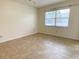 This bedroom showcases neutral walls, tile flooring, and a large window for ample natural light at 3311 Teeside Dr, New Port Richey, FL 34655