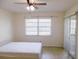 Bright bedroom featuring a large window, tiled floors, ceiling fan and sliding glass door at 3311 Teeside Dr, New Port Richey, FL 34655