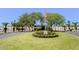Community entrance with manicured lawn, landscaping, and American flag at Seven Springs Golf & Country Club at 3311 Teeside Dr, New Port Richey, FL 34655