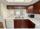 Well-lit kitchen featuring white countertops and wooden cabinetry with a view to the dining area at 3311 Teeside Dr, New Port Richey, FL 34655