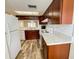Kitchen with plenty of storage, white appliances, and wood-look tile at 3311 Teeside Dr, New Port Richey, FL 34655