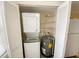 Laundry closet with stacked washer/dryer unit, water heater, and storage shelving at 3311 Teeside Dr, New Port Richey, FL 34655