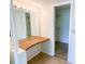 Bathroom vanity features Hollywood lighting, tile flooring, and easy access to walk-in closet at 3311 Teeside Dr, New Port Richey, FL 34655