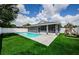 Beautiful backyard boasts a pool, screened patio, lush lawn, and play structure at 382 Tavernier Cir, Oldsmar, FL 34677