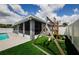 Backyard view featuring pool, screened lanai, lush lawn, and a wooden play structure at 382 Tavernier Cir, Oldsmar, FL 34677