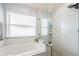 Bright bathroom featuring a soaking tub, tile surround, and a window for natural light at 382 Tavernier Cir, Oldsmar, FL 34677